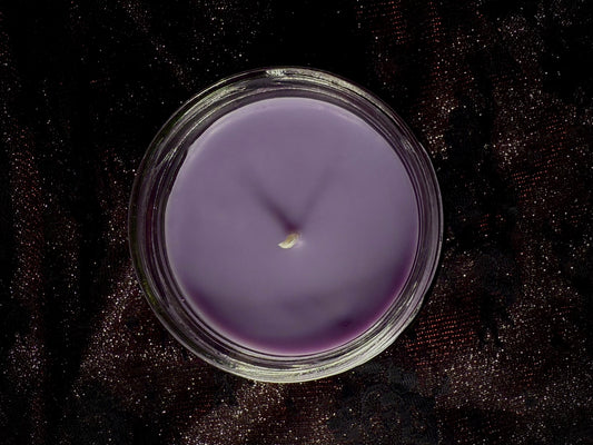 Top-down view of the Claudia candle, unlit wick in purple wax