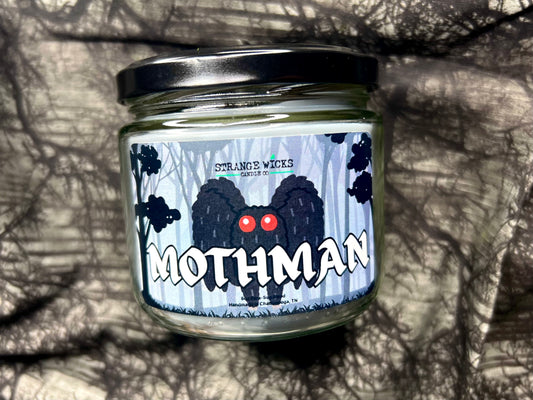 Close-up of the Mothman candle label with red-eyed creature artwork