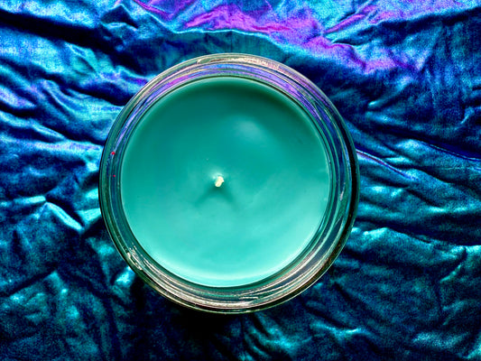 Top-down view of Jinx candle showing turquoise wax and centered wick