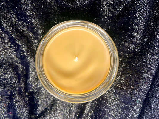 Top-down view of Hozier Candle showing smooth peach wax surface and wick