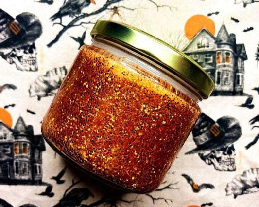 Close-up of orange glitter Hocus Pocus candle jar with gold lid