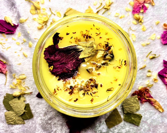 Top-down view of Bee Kind candle wax topped with dried flower petals