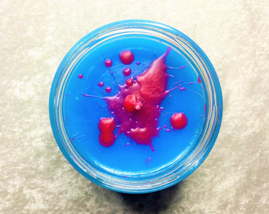 Top-down of A Slice of Life candle with red wax drips on blue wax