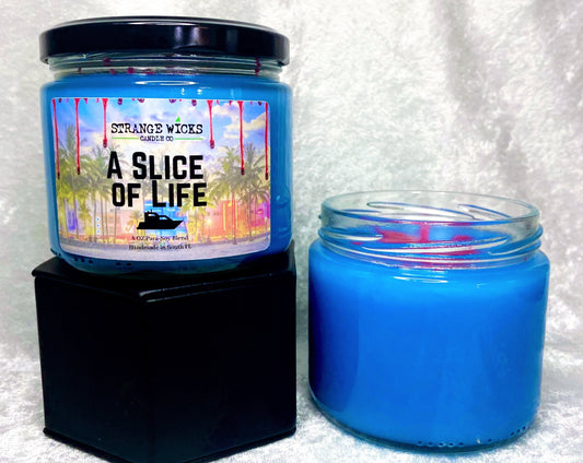 A Slice of Life candle on gift box next to an open unlabeled candle