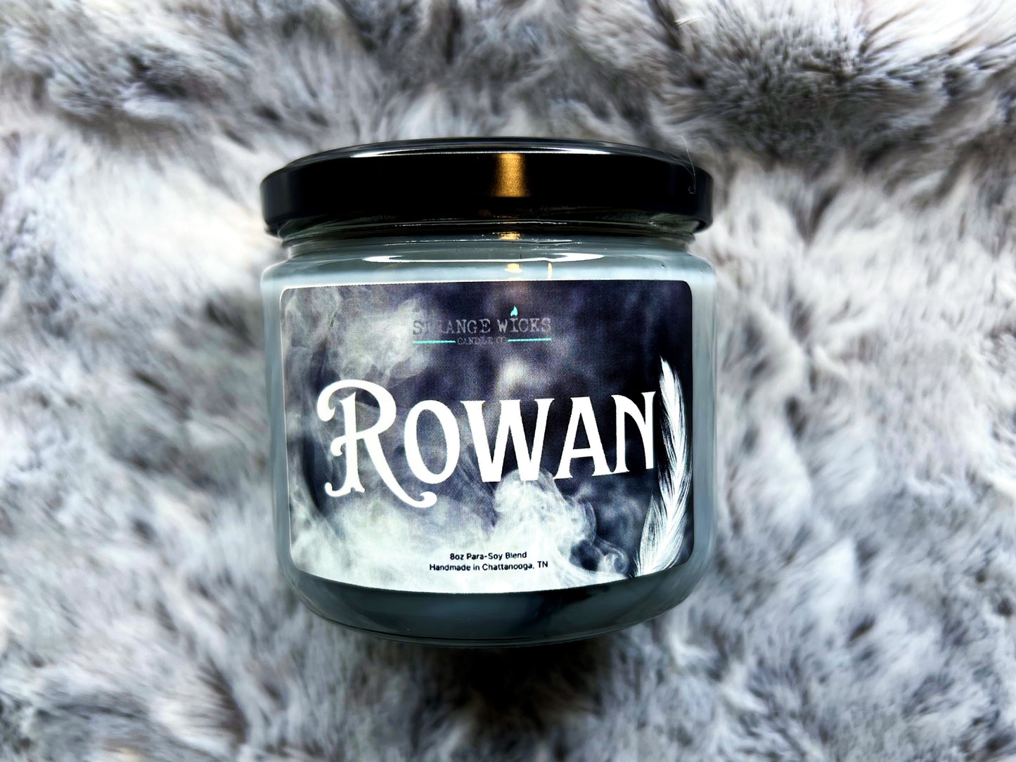 Rowan Candle jar with black lid and smoky feather label, front view