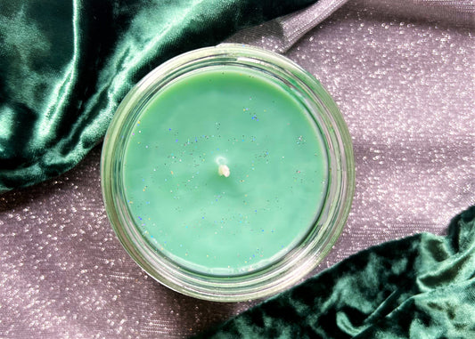 Top-down of Sassenach candle: green glittered wax and wick