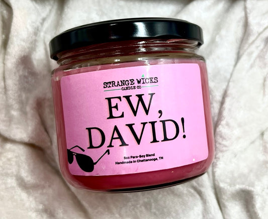 Ew, David candle in glass jar with black lid and pink label