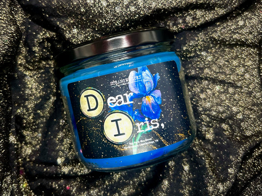 Angled close-up of Dear Iris candle label with typewriter keys and blue iris art