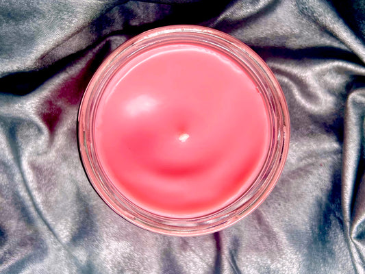 Top-down view of the Blink-182 candle, unlit wick in pink wax