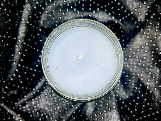 Top-down view of the Violet candle, white wax with pink glitter and unlit wick