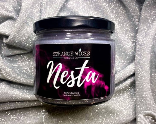 Nesta candle jar with black lid and flame-design label on silver fabric