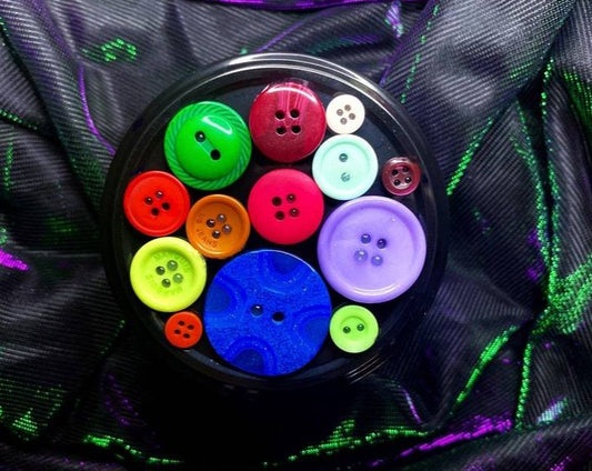 Top-down view of Other Mother candle lid decorated with colorful buttons