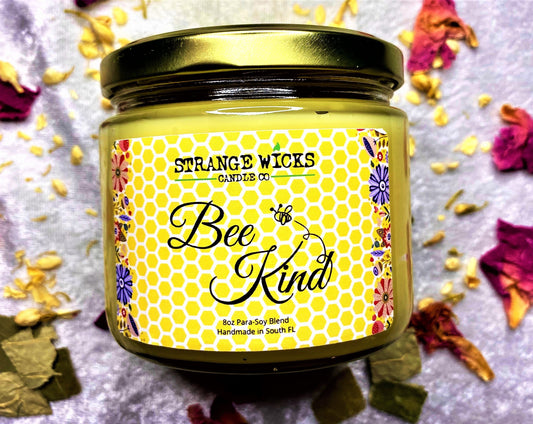 Closed Bee Kind candle jar with gold lid, dried petals scattered around