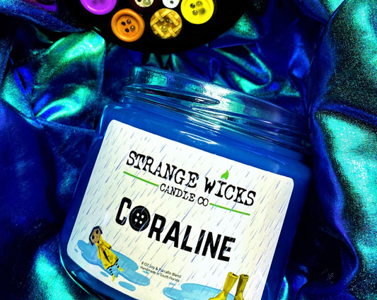 Open Coraline candle among buttons and thread on blue shimmer fabric