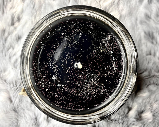 Top-down view of The Hallows Candle with glittery black wax and centered wick
