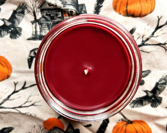 Top-down view of Nevermore Candle with smooth red wax and centered wick