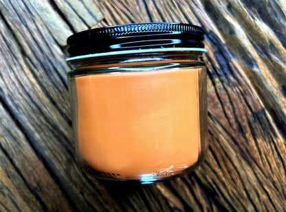 Back view of the orange This is My Reading Candle jar on wood