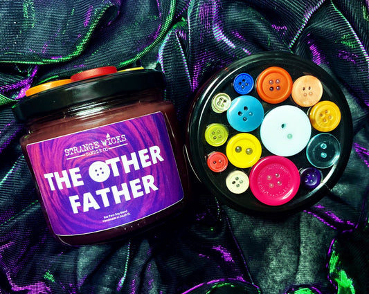Coraline Candle Collection – The Other Father candle beside its button-covered lid
