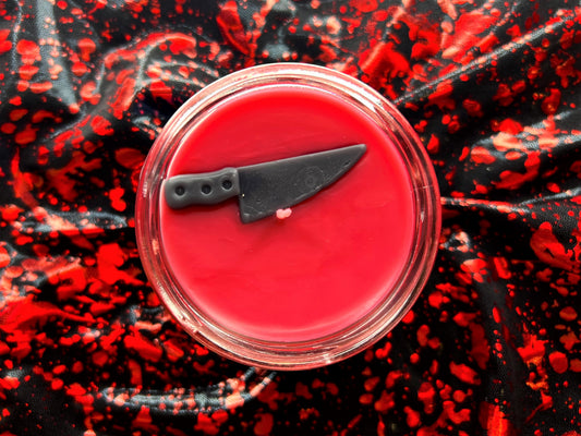 Top view of Wanna Play? Chucky candle, red wax with small knife decoration